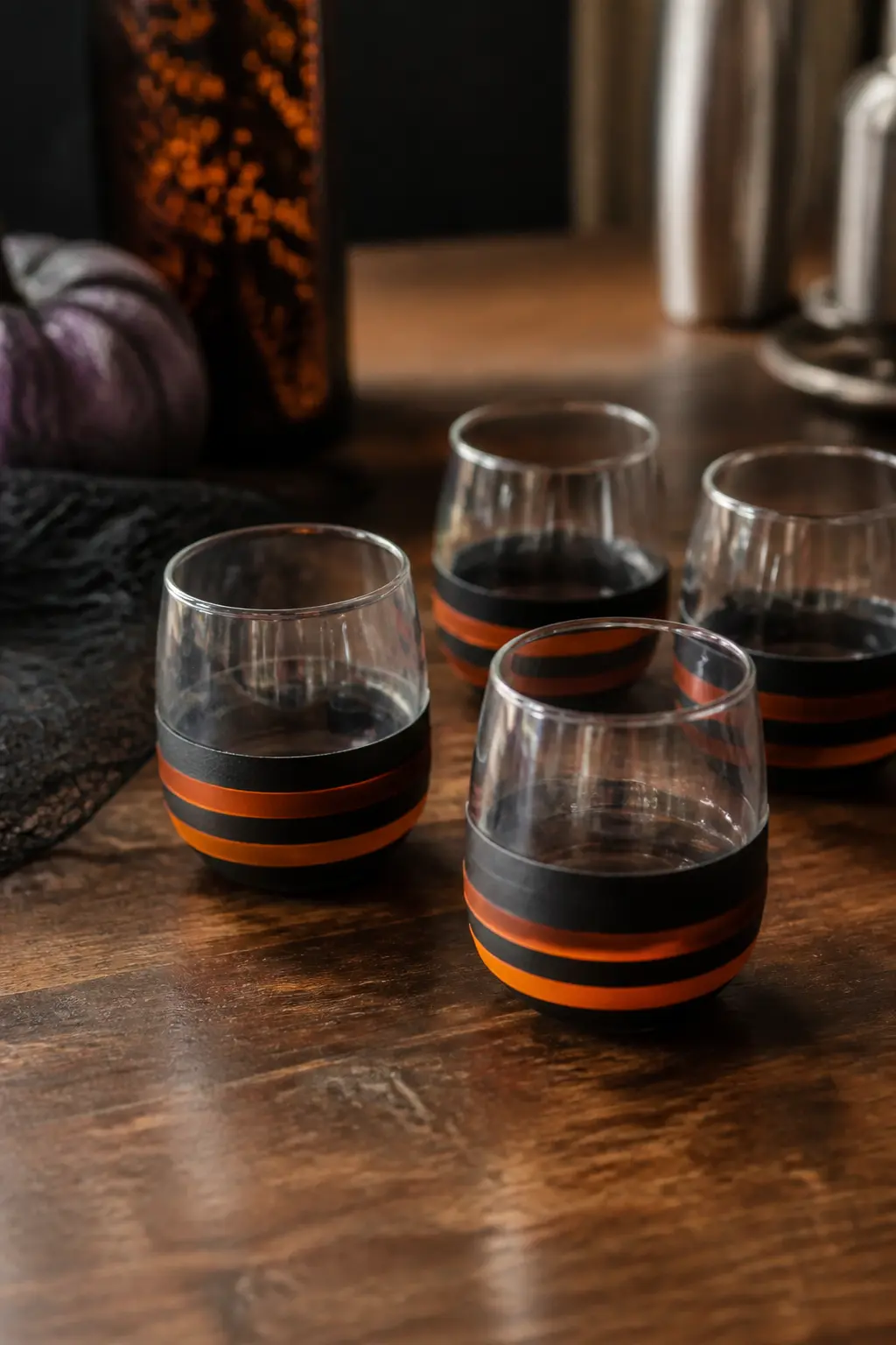 Washi Tape Cauldron Base — Wrap the base of a stemless glass with two overlapping bands of black washi tape so it reads as a little cauldron sitting on your