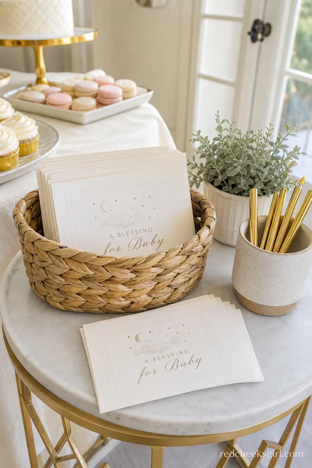 A Basket of Blessing Cards for Baby — A shallow basket, filled with small ivory cards and a cup of gold pens, invites guests to leave a wish or a piece of