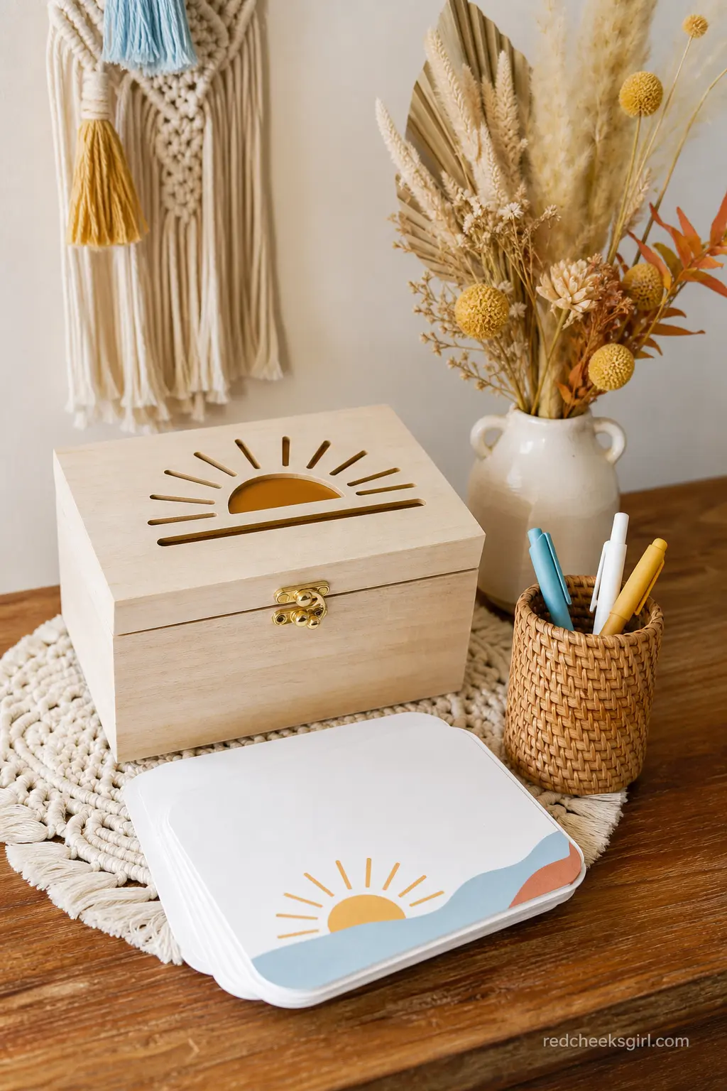 Advice for Baby Card Box — A small wooden box with a sun cutout in the lid, sitting beside a stack of blank cards and a pen holder, invites guests to leave a