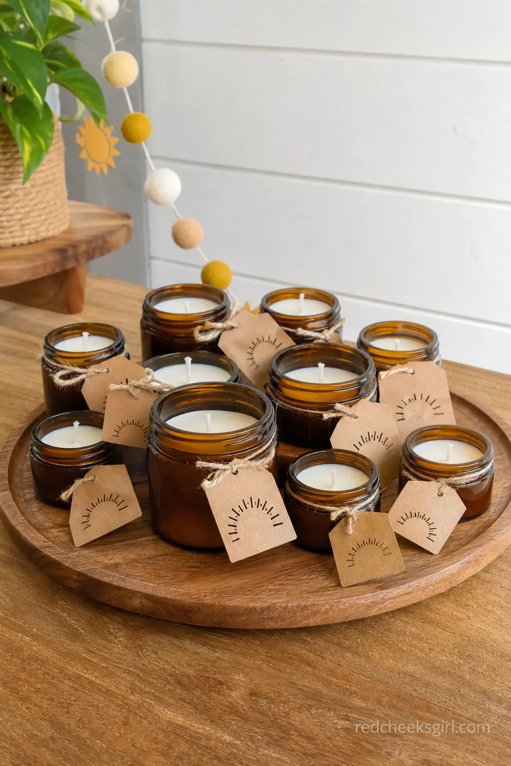 Amber Jar Candle Favors — Mini candles in amber glass jars, arranged in a loose cluster on a tray rather than a rigid grid, catch the light beautifully and