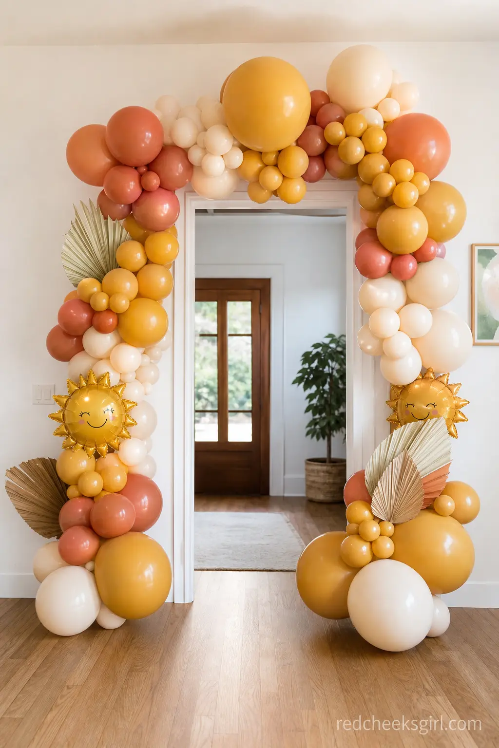 Golden Balloon Arch Entrance — An organic balloon arch over the front door announces the theme before anyone steps inside. Here comes the sun baby shower theme