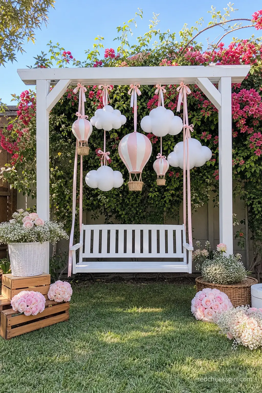 Cloud Swing Garden Backdrop — For an outdoor shower, a wooden swing dressed with blush ribbon and hanging cotton cloud shapes turns an ordinary garden corner