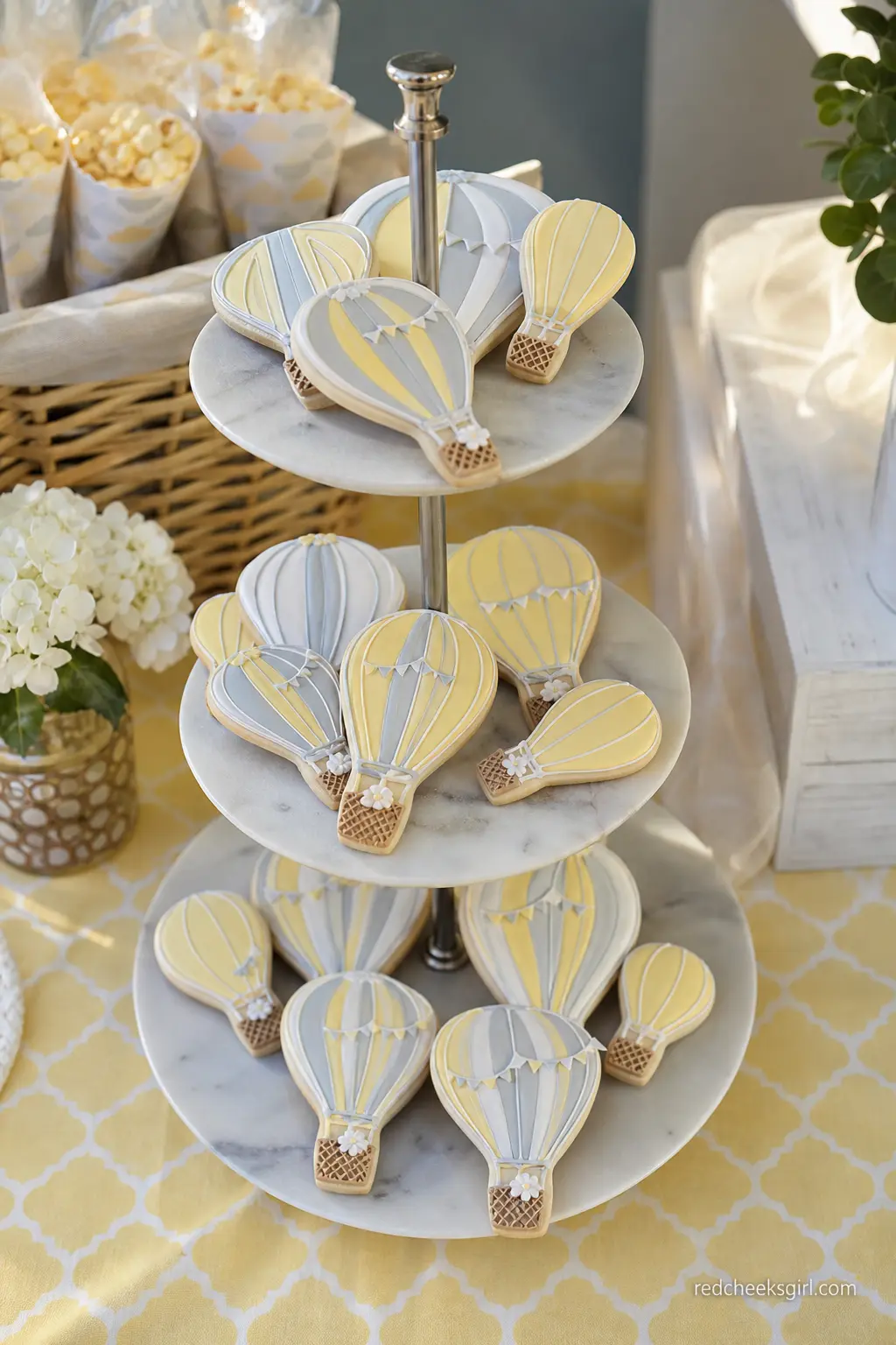 Pastel Balloon Cookie Tiered Stand — Iced cookies cut into hot air balloon shapes, in buttery yellow and soft grey, look substantial stacked on a three tier