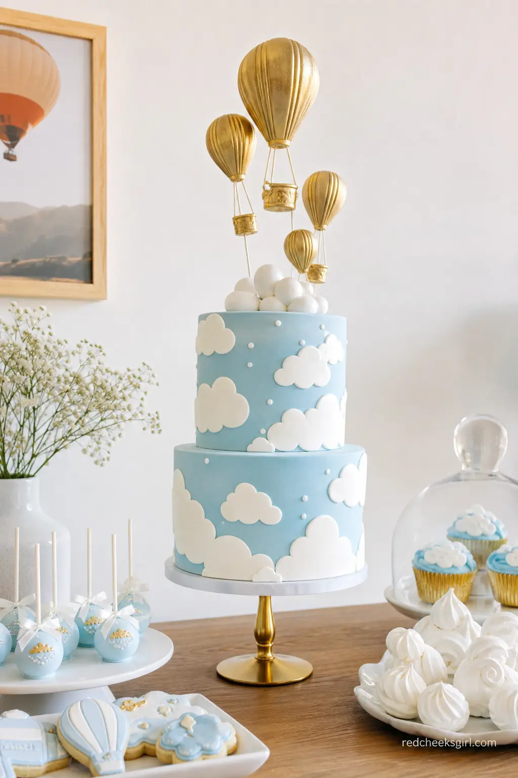 Powder Blue Cloud Cake Table — A tall cake shaped into drifting cloud tiers, finished in powder blue and white with gold leaf balloons rising from the top