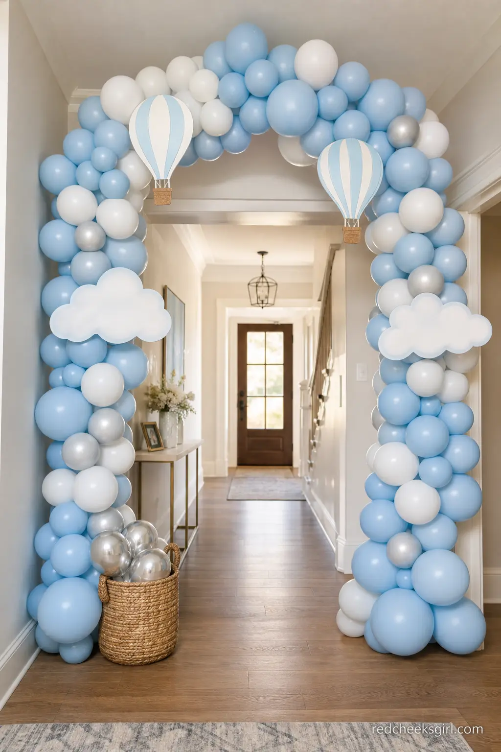 Sky Blue Balloon Arch Entrance — A balloon arch in sky blue and white turns a plain entry hallway into the first clue of the theme, before anyone reaches the