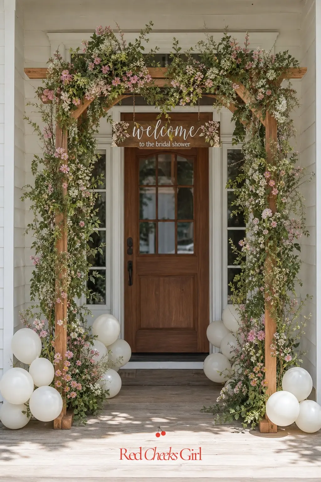 Wildflower Welcome Arch — A simple wooden arch dressed in wildflowers greets guests before they even reach the door. Love is in bloom bridal shower theme
