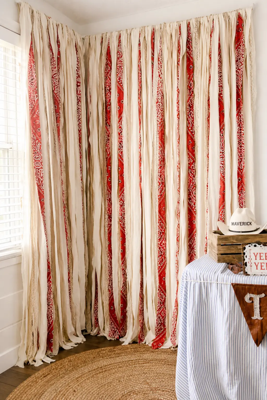 Fringe and Bandana Streamer Curtain — A full wall of ivory fringe streamers, with bandana print fabric strips woven through at intervals, gives movement and