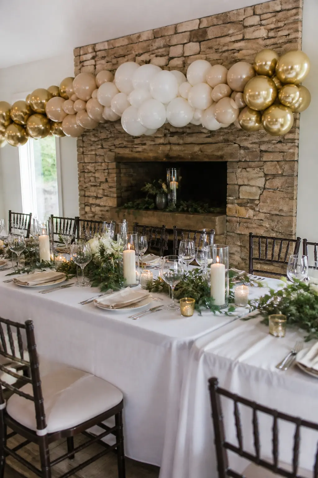 Gold Fading into White Along a Wedding Top Table — This garland runs horizontally behind the top table rather than arching over it. Ombre balloon arch