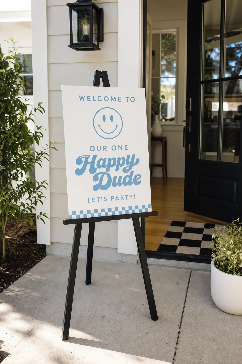 Freestanding Welcome Sign — A black wooden easel holding a white sign board with sky blue lettering at the entrance tells guests instantly which door to walk