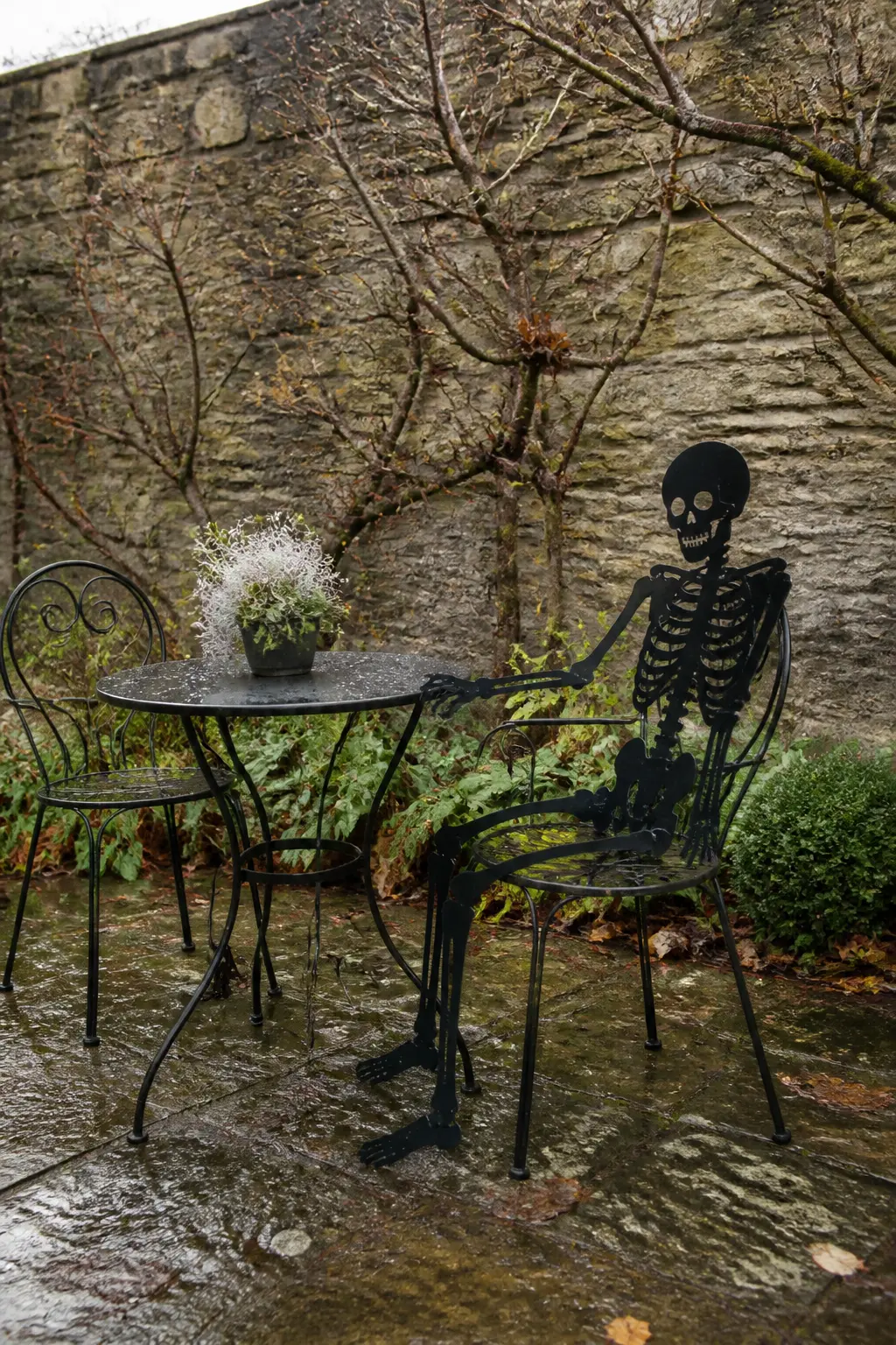 Iron Skeleton Silhouette Seated on a Garden Chair