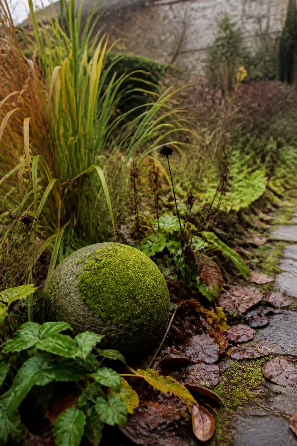 Moss-Covered Stone Sphere in a Border