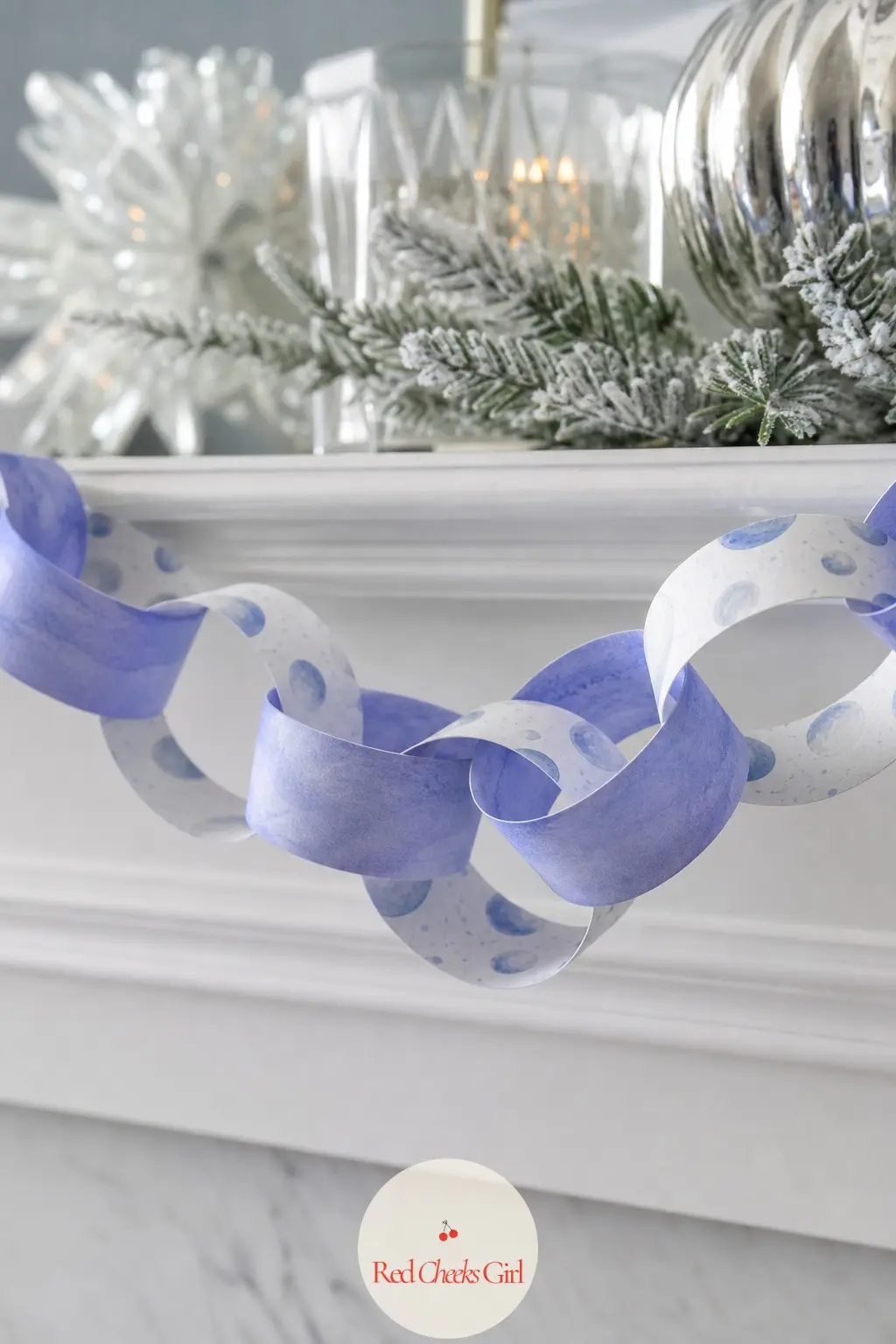 Snowball Pom Paper Chain — Round white pom-like snowball shapes printed in a scattered pattern against icy periwinkle, textured with tiny shading lines so each