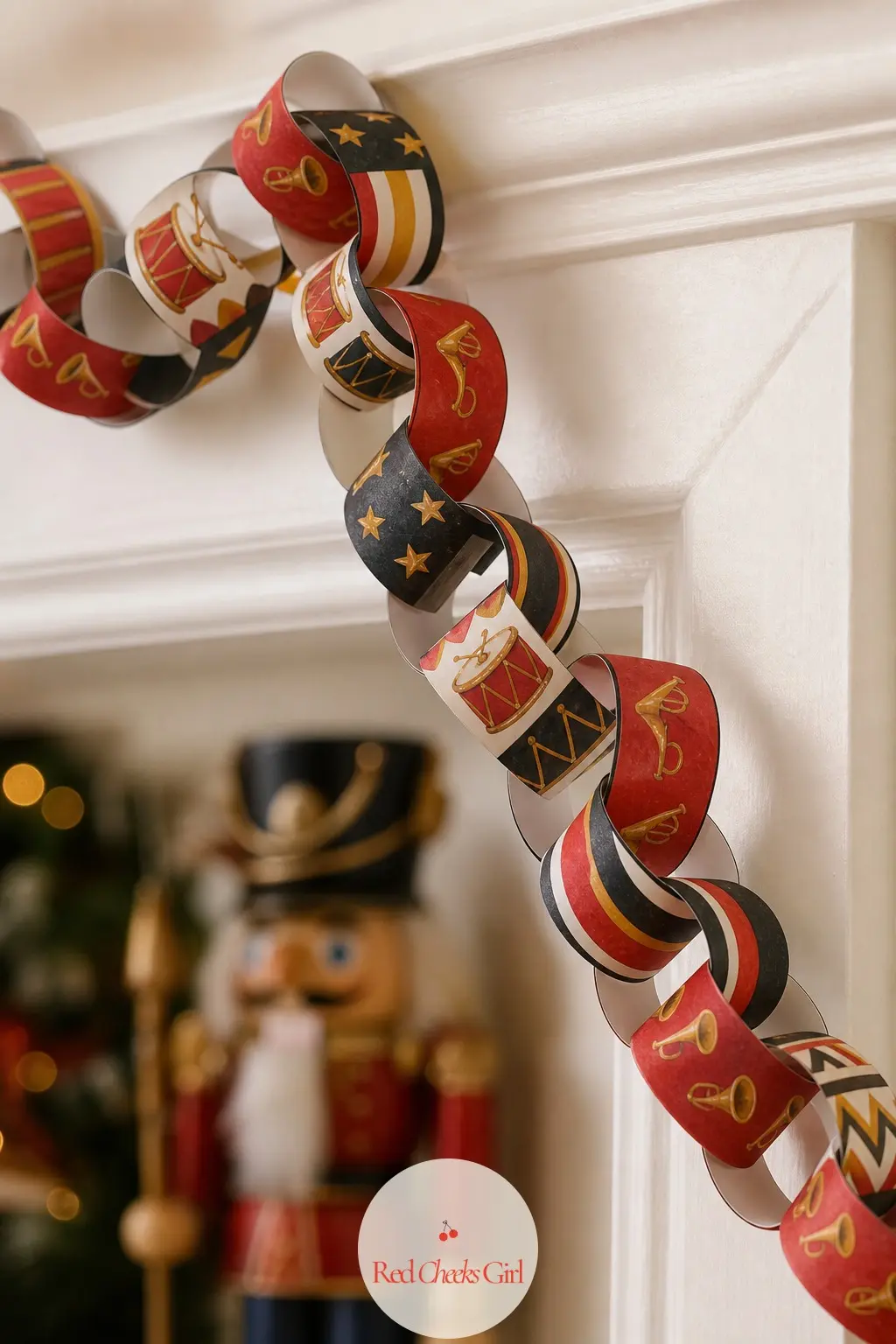 Toy Drum and Trumpet Paper Chain — A parade-ground palette of black, cardinal red and gold, the strips patterned with tiny toy drums, trumpet bells and