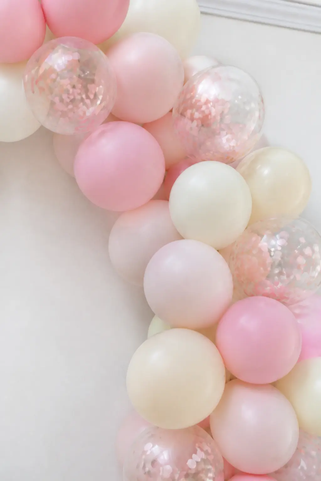 Pastel Arch in Confetti-Filled Clear Balloons Among Matte Pastels — Clear balloons filled with pastel confetti scatter light in a way that no printed or matte