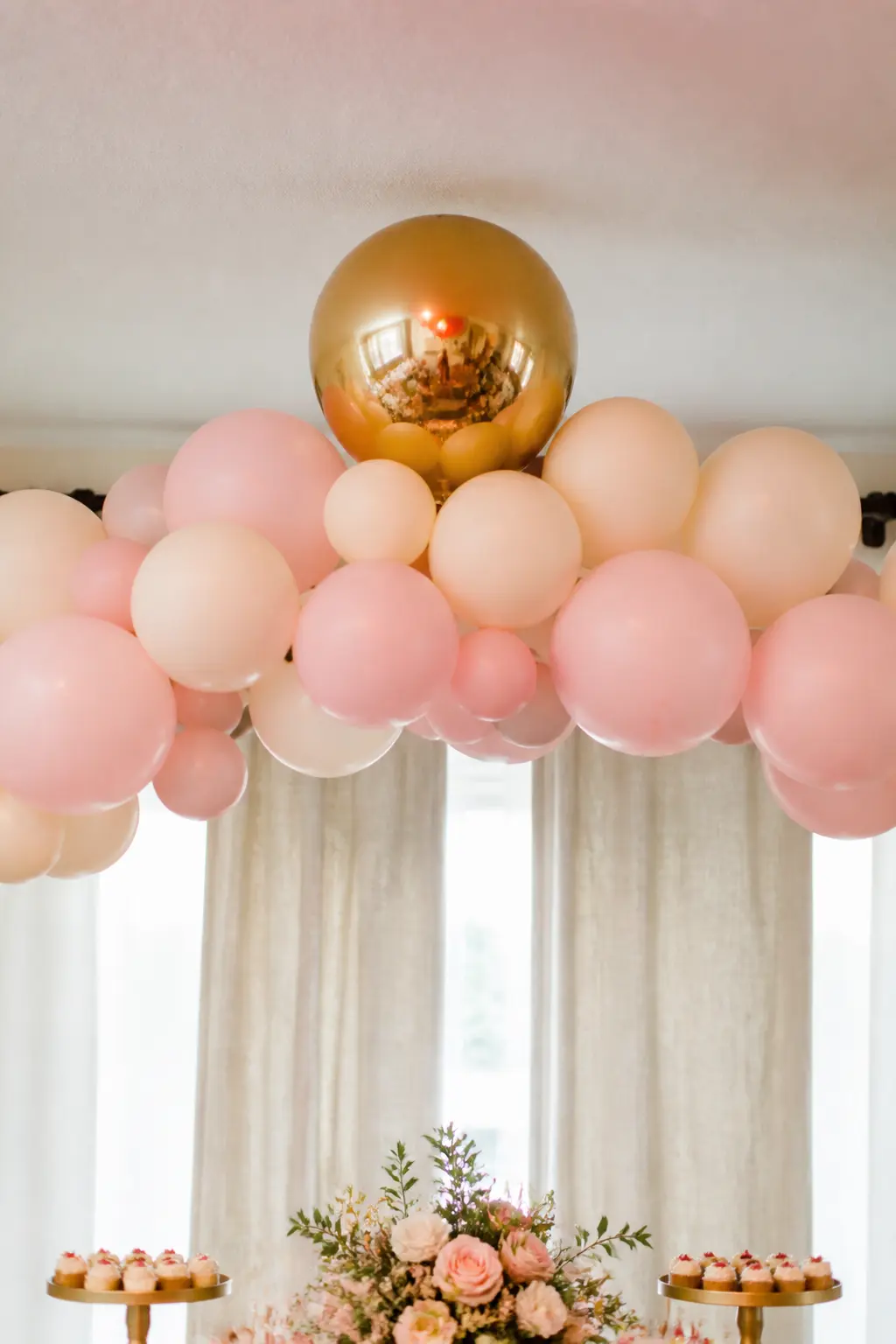Pastel Arch with One Metallic Gold Balloon at the Top Point — One metallic balloon at the crown of an otherwise all-matte arch catches every eye without