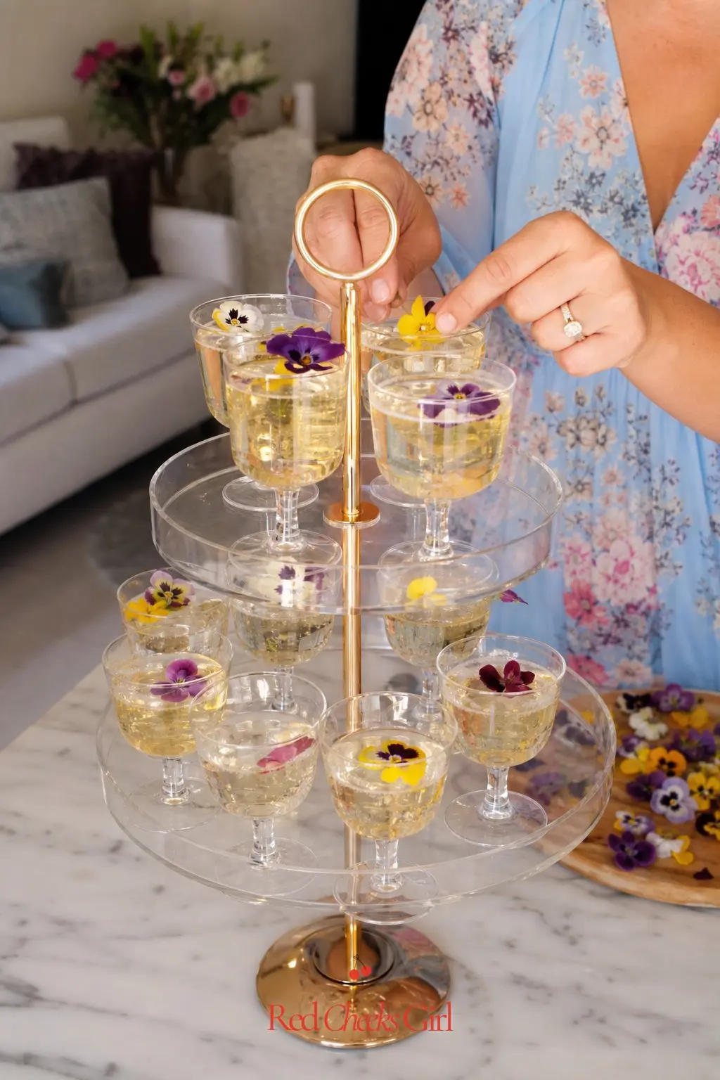 Bubbly Flight Station — A tiered acrylic stand holding small pours of prosecco, each glass topped with a single edible flower, lets guests taste their way