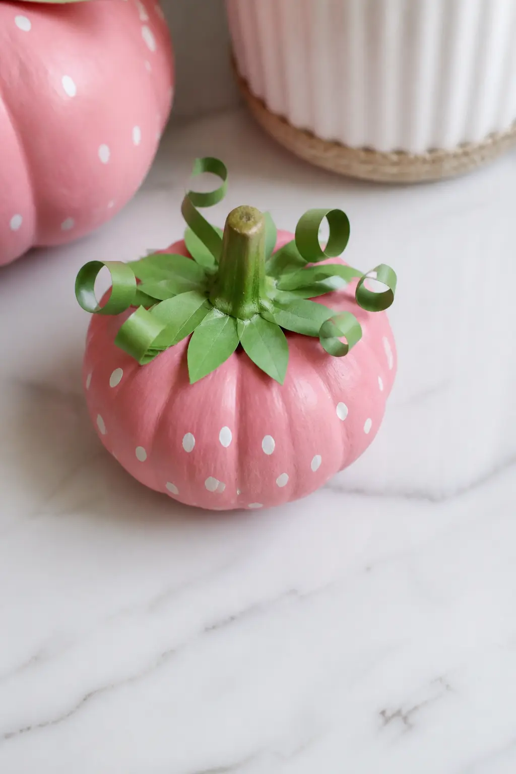 Blush Strawberry Pumpkin — Paint the pumpkin in two coats of warm blush, then add tiny red-tipped seeds across the skin with a fine brush. Pink painted pumpkin