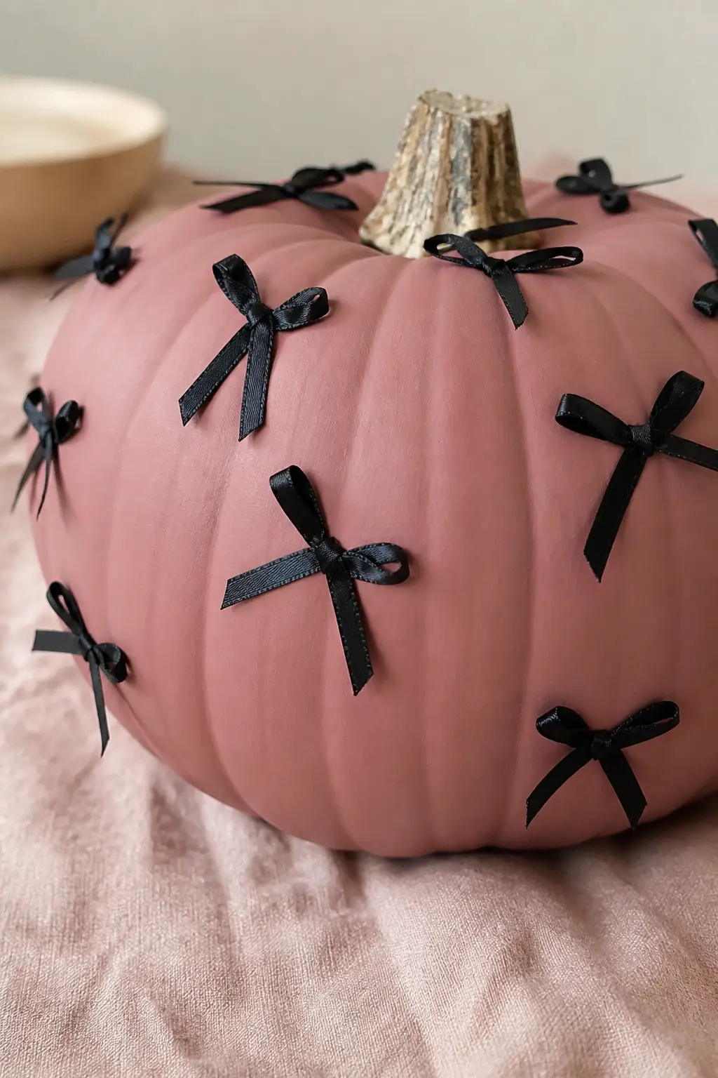 Dusty Rose With Tiny Black Bows — Scatter small pre-made black satin bows across the surface of a dusty rose pumpkin, attaching each one with a single