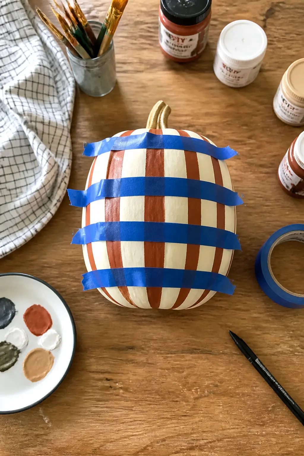 Paint the Vertical Stripes First, Let Them Dry Fully, Then Do the Horizontal — The order of directions matters. Plaid painted pumpkin
