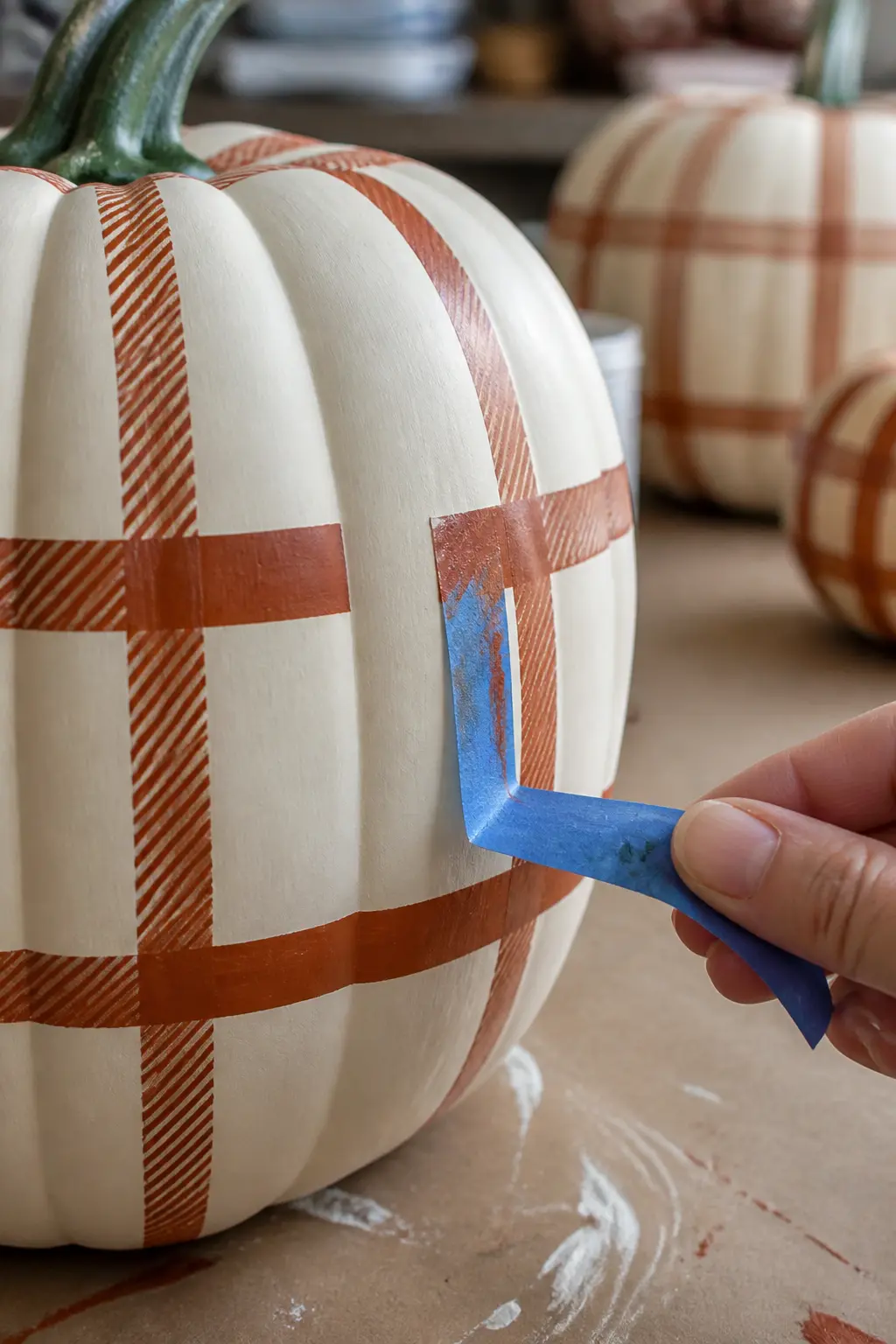 Peel the Tape While the Paint Is Still Slightly Tacky for the Cleanest Edge — This is the step most people get wrong. Plaid painted pumpkin
