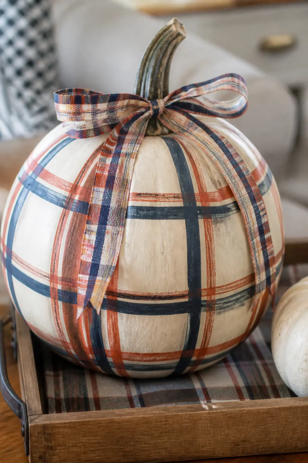 Plaid With a Matching Plaid Ribbon at the Stem on a Cream Pumpkin — A plaid ribbon tied at the stem in the same colour palette as the painted plaid makes this