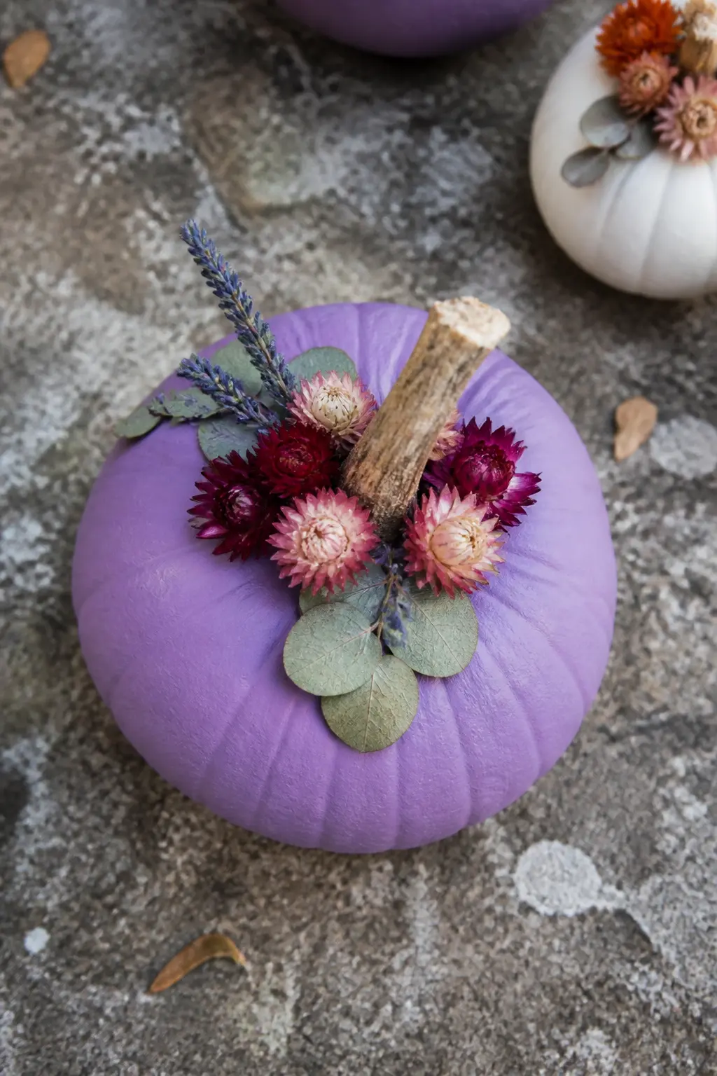 Lavender With Dried Flowers Glued at the Stem — Paint the pumpkin lavender and leave the surface entirely plain. Purple painted pumpkin