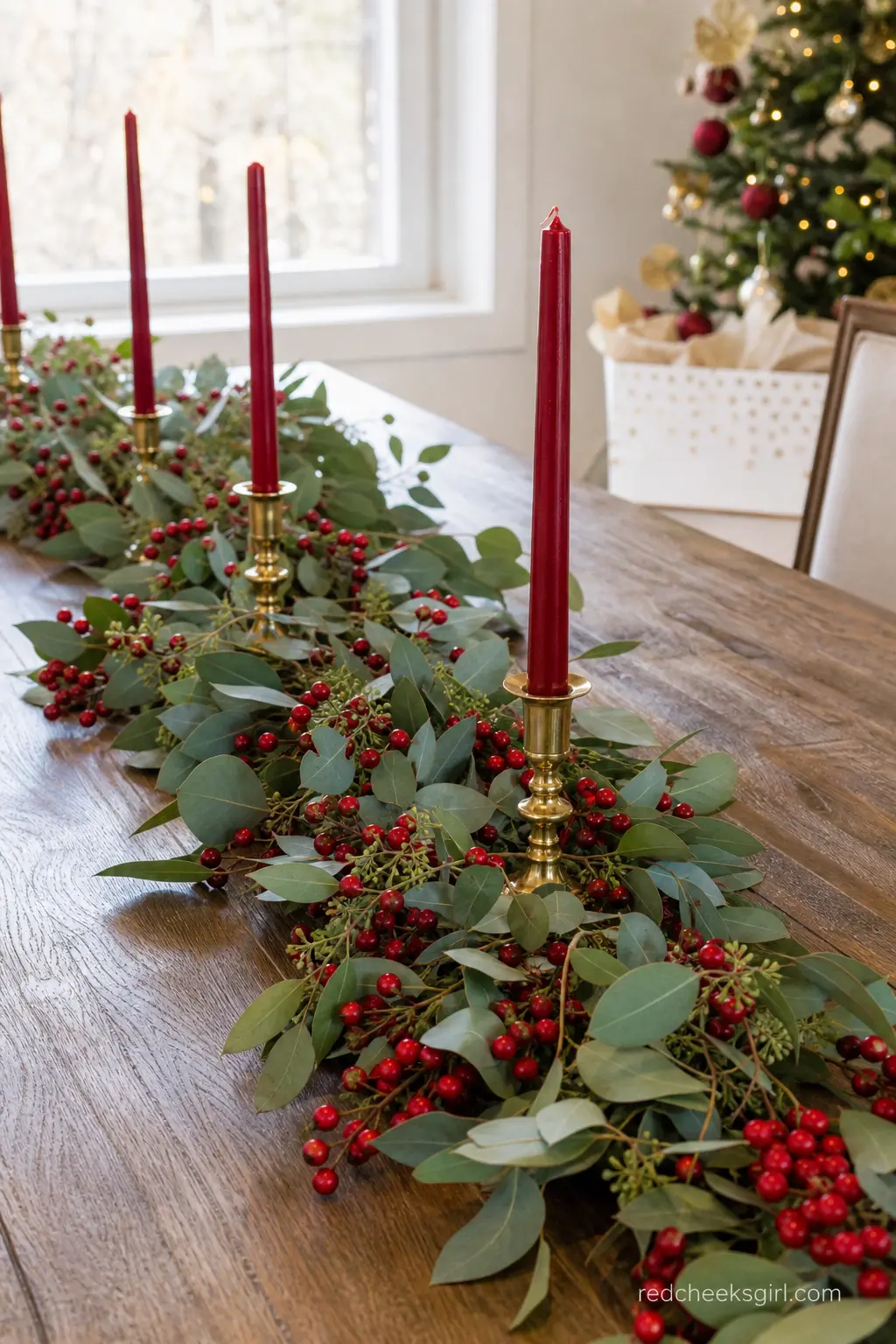 Cranberry and Eucalyptus Garland Runner with Taper Candles — Fresh eucalyptus studded with cranberries stretches down the center of the table, three red taper