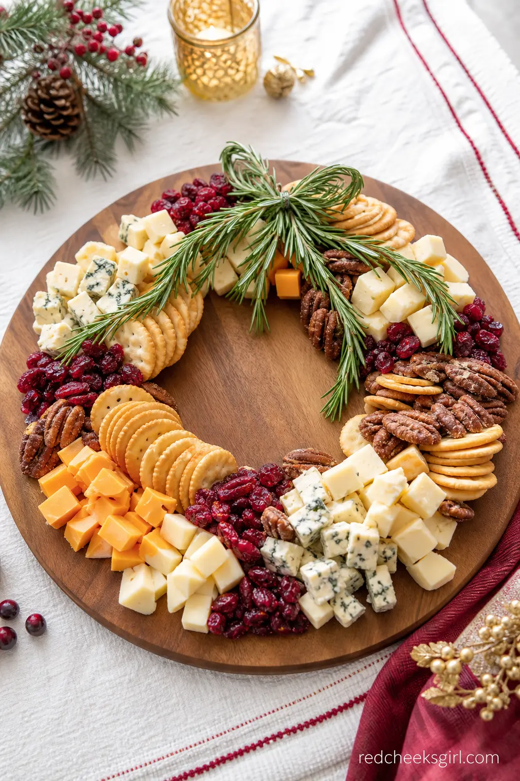 Rosemary Wreath Cheese Board with Cranberries and Candied Pecans — A round wood board arranged as a wreath of cheeses, crackers, cranberries and candied pecans