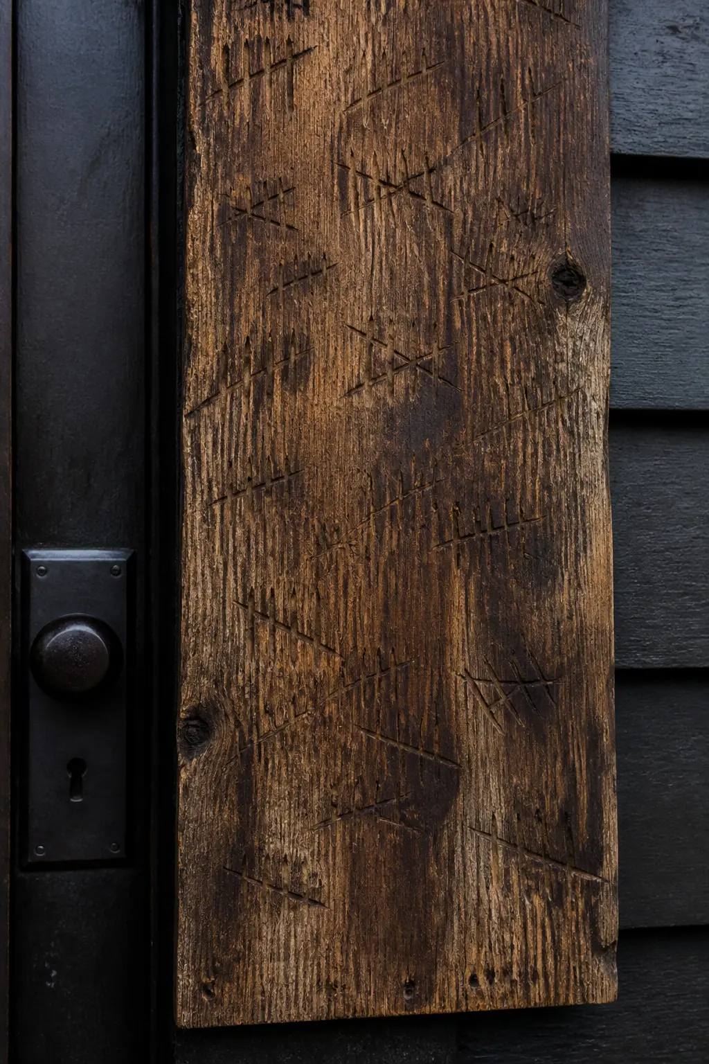 Tally Marks Scratched into a Wooden Board by the Door