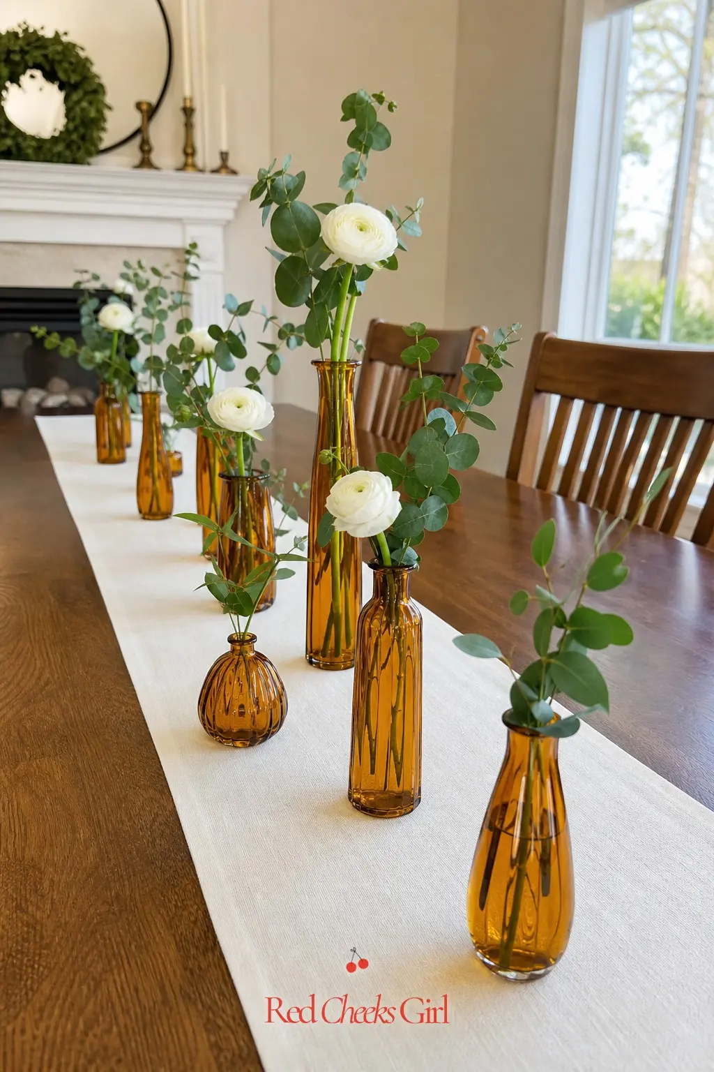 Amber Glass Bud Vase Runner — A runner of amber glass bud vases down the center of a long table reads as expensive and takes about twenty minutes to assemble.