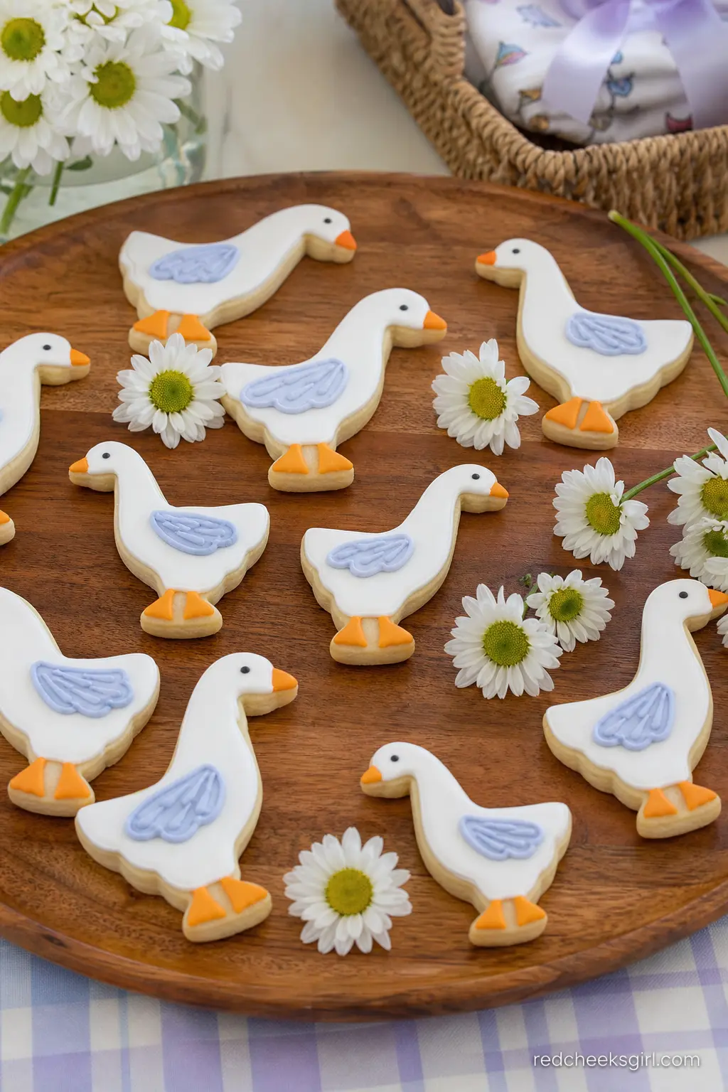 Goose Cookie Platter — A wooden platter of iced sugar cookies shaped like waddling geese, each one white with a small orange beak and periwinkle wing detail