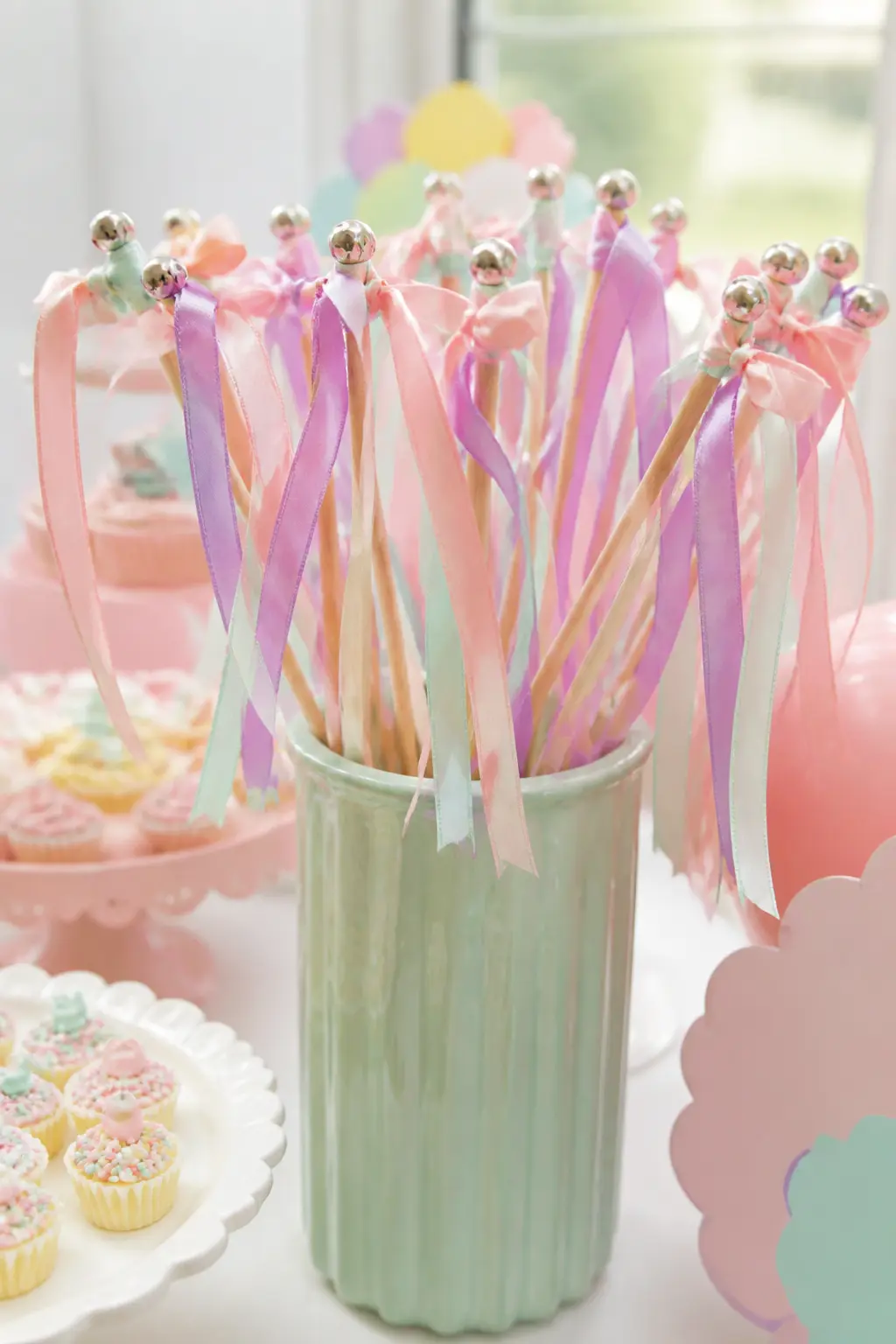 Pastel Ribbon Wand Favour — A wooden dowel wrapped in washi tape, with three lengths of satin ribbon in the party colours tied at the top, is a ribbon wand