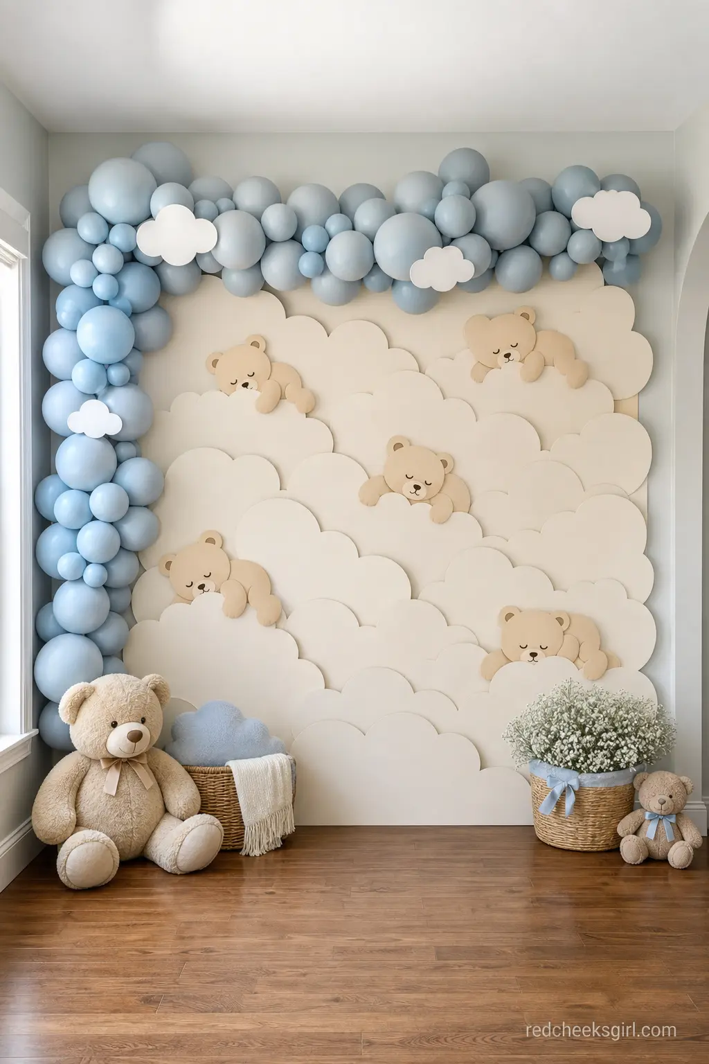 Sleepy Cloud Wall Backdrop — Cream paper clouds and a dusty blue balloon garland turn one plain wall into the whole theme in under an hour. Teddy bear baby