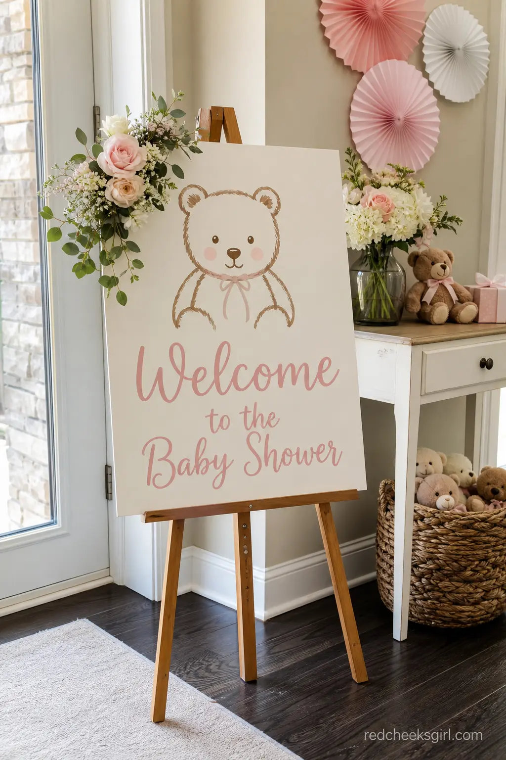Welcome Sign With A Painted Bear — A foam board or wood easel sign with a simple painted bear and blush pink script lettering greets guests at the entrance and