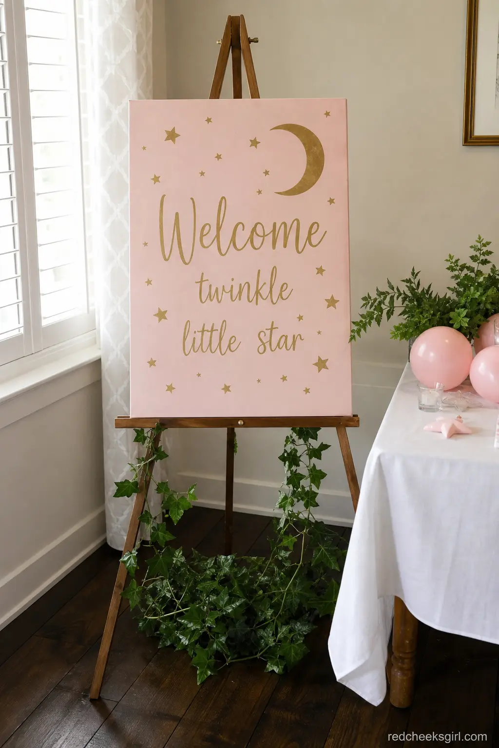 Twinkling Welcome Sign Easel — A blush and gold welcome sign on a simple wooden easel gives directions without a single loud color. Twinkle little star baby