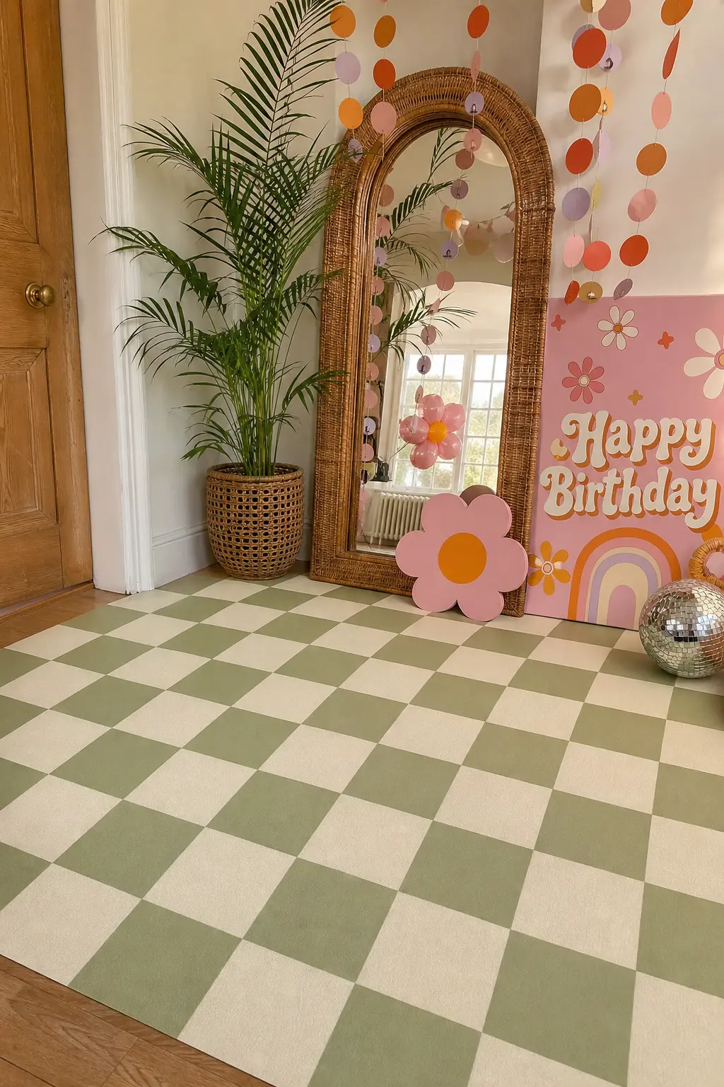 Checkerboard Floor Photo Spot — A sage and cream checkerboard vinyl mat laid flat gives the photo zone graphic punch that colored balloons alone cannot. Two
