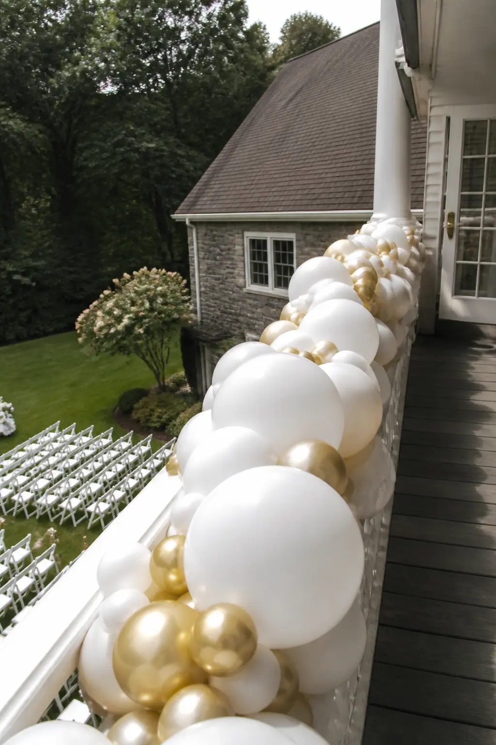White and Gold Garland Along a Balcony Railing — A garland in white and chrome gold runs the full length of a balcony railing, fixed to the railing face so it