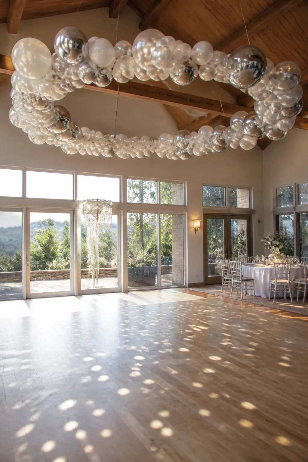 White, Pearl and Chrome Silver Circle Above the First-Dance Floor — A full balloon circle in white, pearl and chrome silver hangs directly above the
