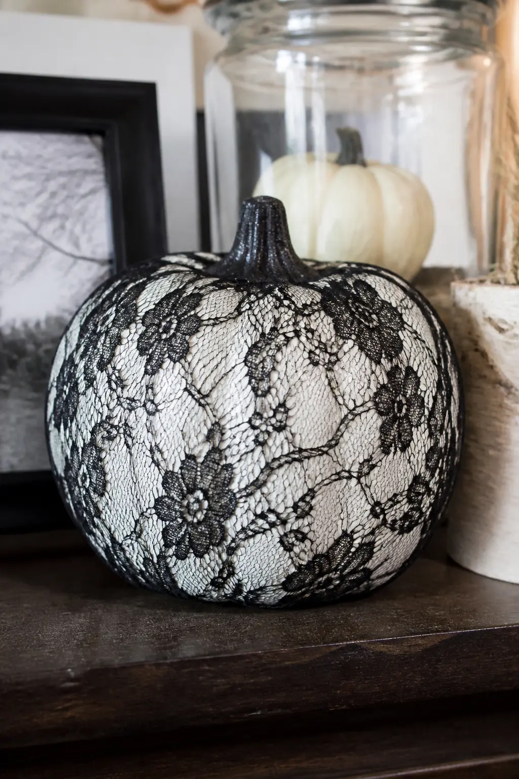 Black Lace Panel — A rectangle of black lace fabric, cut to cover roughly one third of the pumpkin's circumference, is glued flat against the front. White