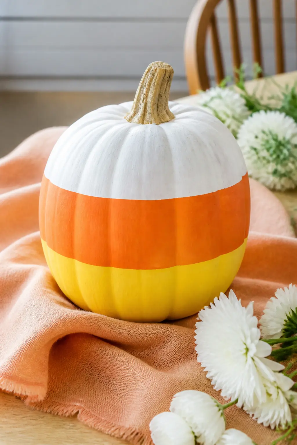 Candy Corn Stripe in Orange and Yellow — The lower half of the white pumpkin is painted in a wide orange band, and a yellow band below that covers the very