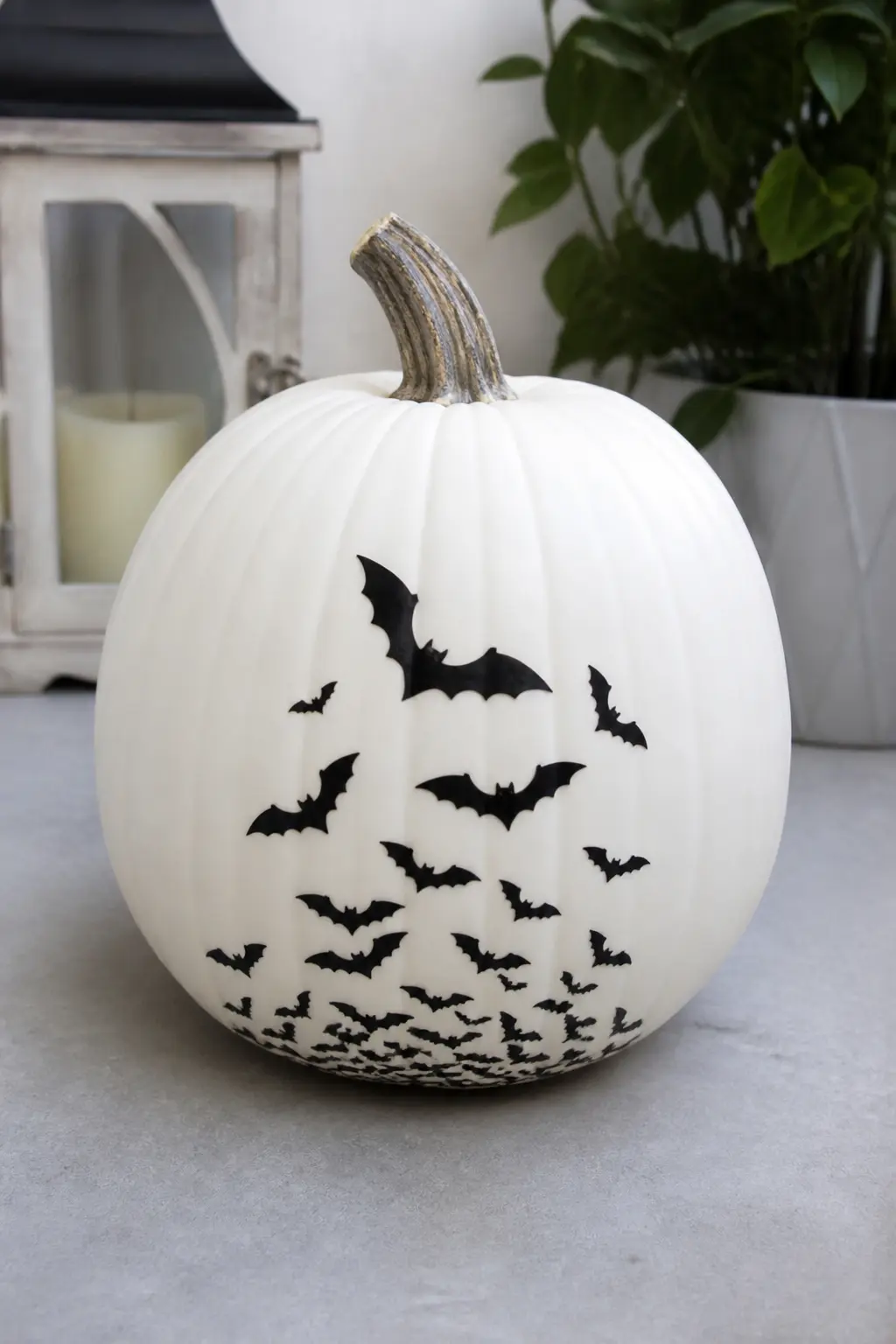 Swarm of Black Bats Climbing From the Base — Small black bat silhouettes painted in graduated sizes appear to swarm upward from the base of the pumpkin, the