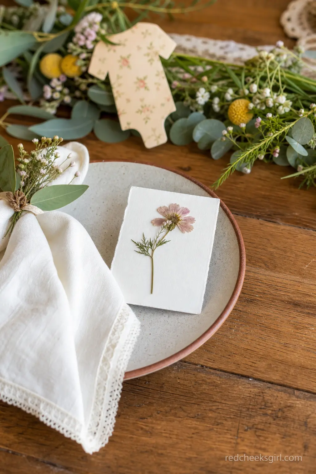 A Single Place Setting With a Pressed Flower Card — For a small, seated shower, the whole theme can live in the place setting rather than a big centerpiece.