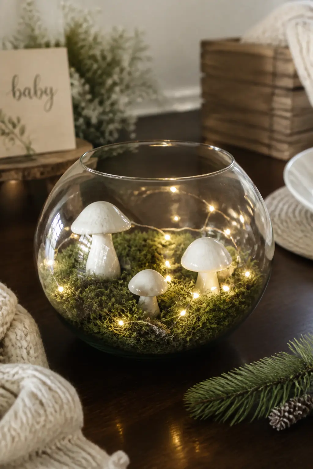 Moss and Mushroom Terrarium Centrepiece — A glass terrarium filled with sheet moss, tiny white ceramic mushrooms and a small fairy-light strand is unexpected