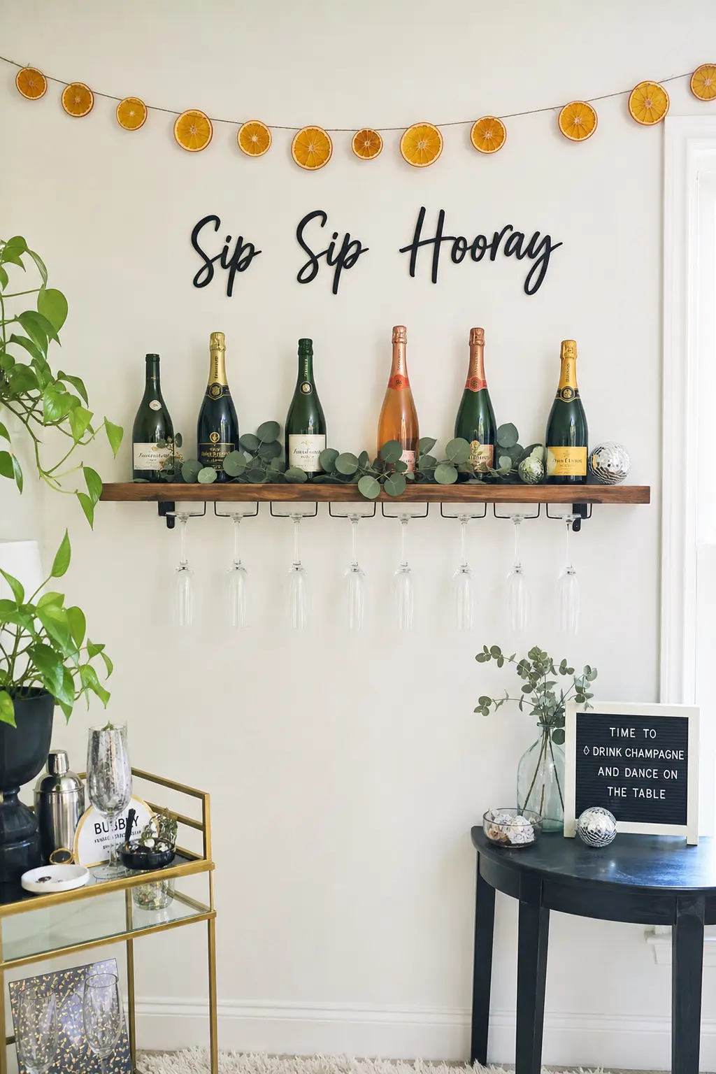 Champagne Wall Photo Corner — A narrow shelf, a few bottles and a run of upside-down flutes turn one bare wall into the spot everyone photographs without a