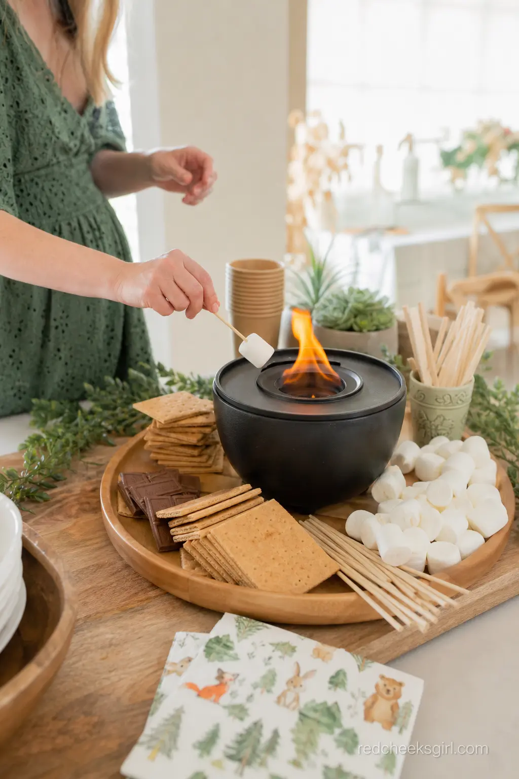 A S'mores Station With a Tabletop Fire Bowl — A small tabletop fire bowl, ringed with graham crackers, chocolate squares and marshmallows on skewers, brings a