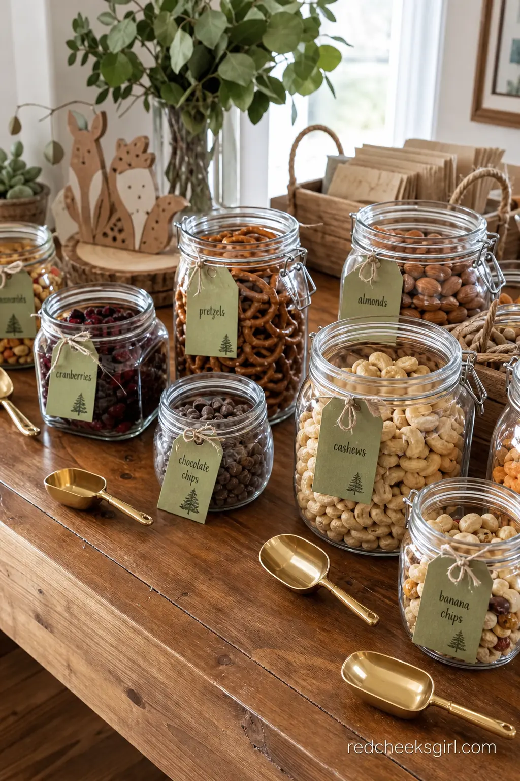 A Trail Mix Bar in Glass Jars — Rows of amber glass jars filled with nuts, dried berries, chocolate chips and pretzel sticks, each labelled with a small sage