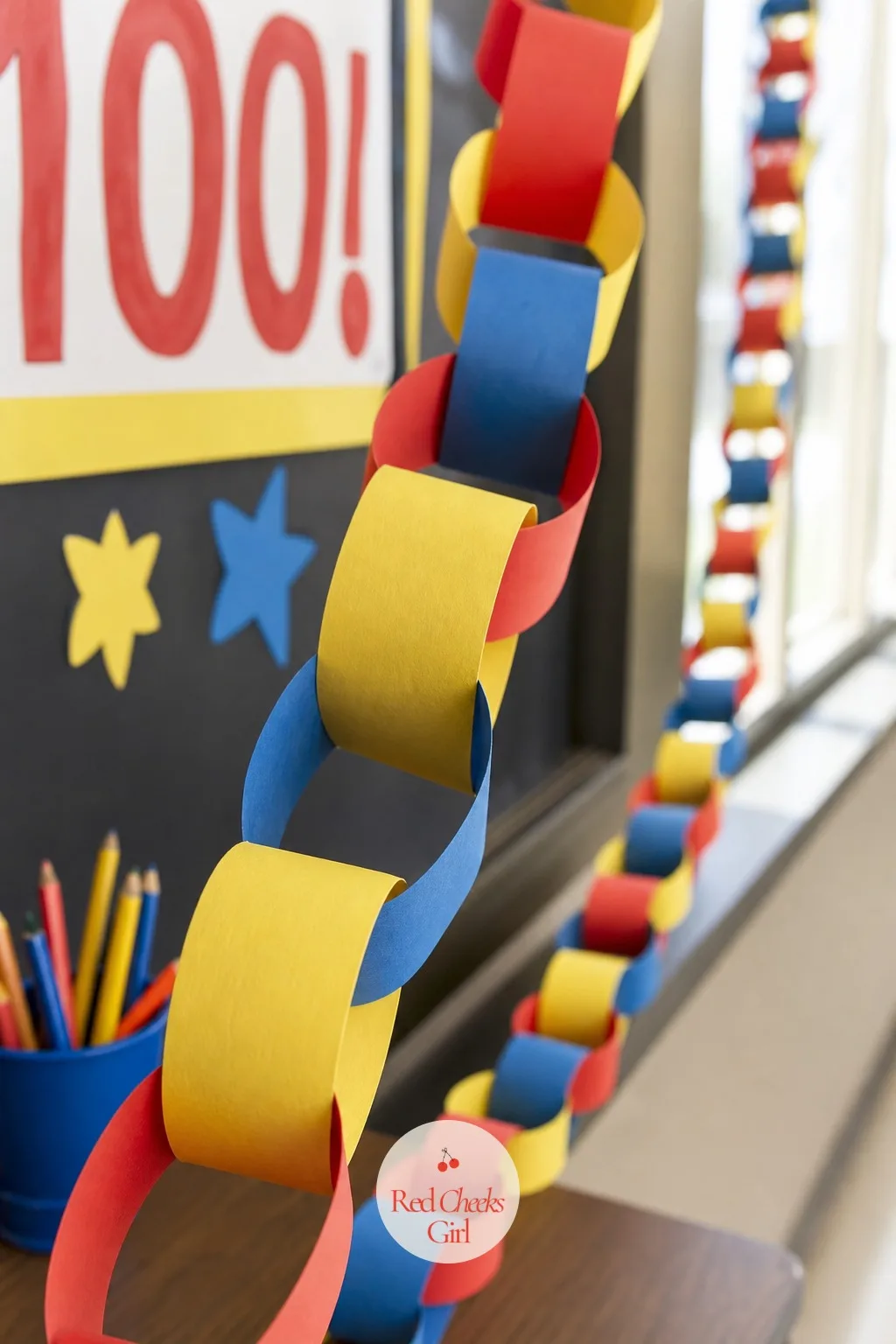 The Hundred Paper Chain — A string of paper loops sounds like a kindergarten holdover, but drape one hundred of them across a doorway and it reads as exactly