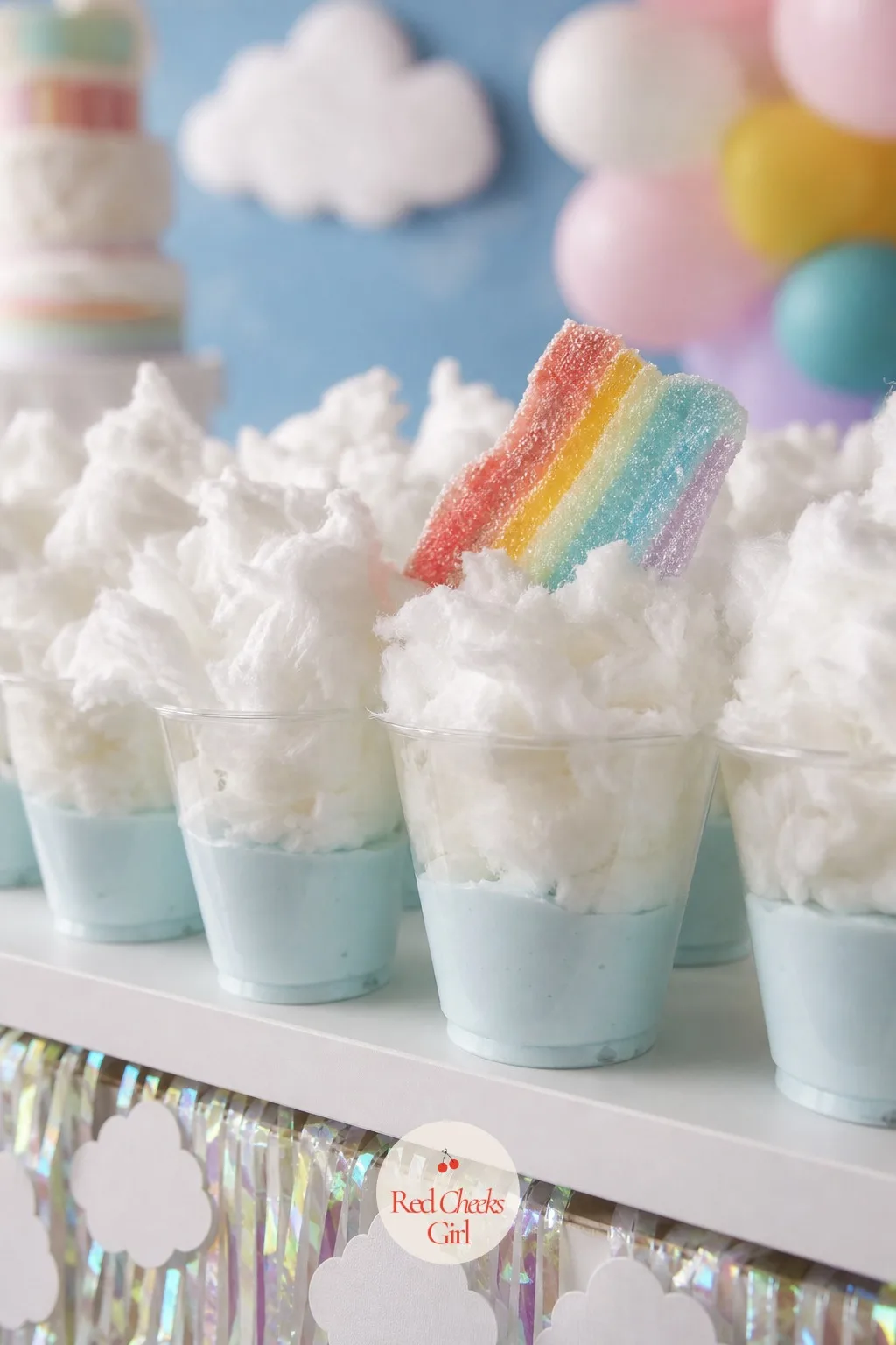Cotton Candy Cloud Cups — Clear plastic cups hold a layer of pale blue pudding or jello at the bottom, with a cloud of torn cotton candy piled loosely on top