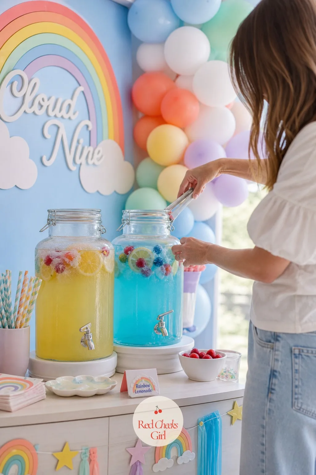 A Rainbow Lemonade Drink Station — A glass beverage dispenser holds the base, with a second smaller dispenser beside it tinted sky blue using butterfly pea or