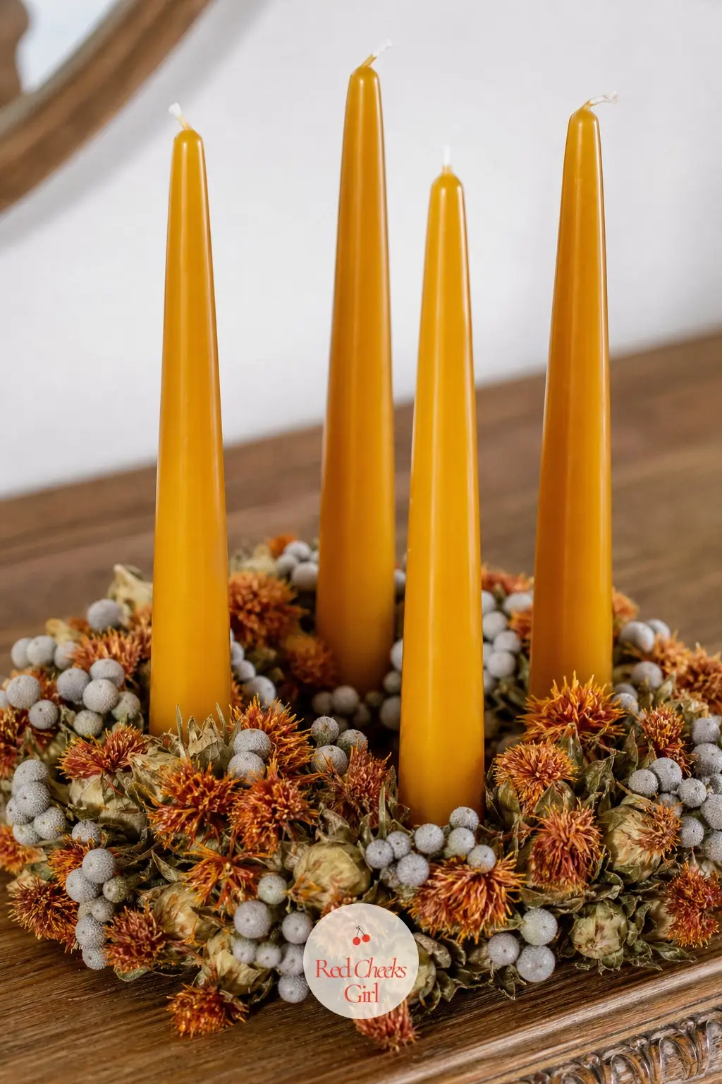 Amber Tapers Rising From a Dried Safflower and Brunia Ring — Dried safflower brings a warm burnt orange, and brunia, those small grey fuzzy balls, adds texture